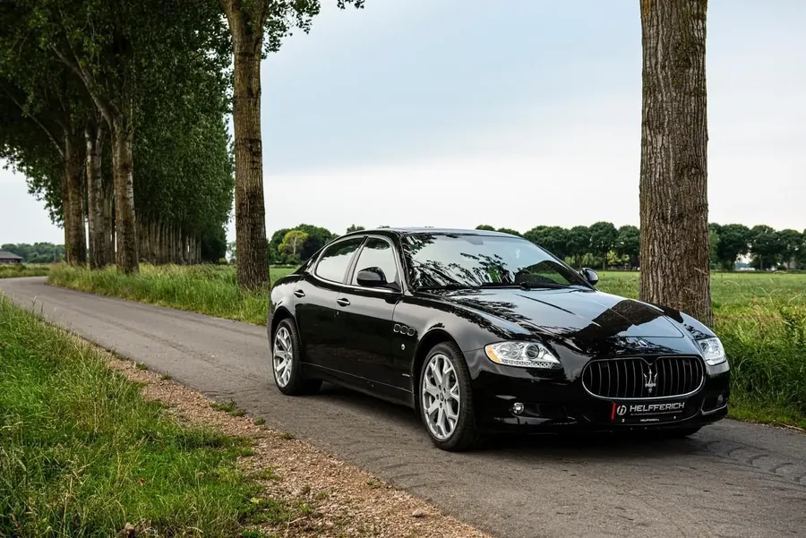 Zwarte Maserati Quattroporte op een landweg tussen populieren
