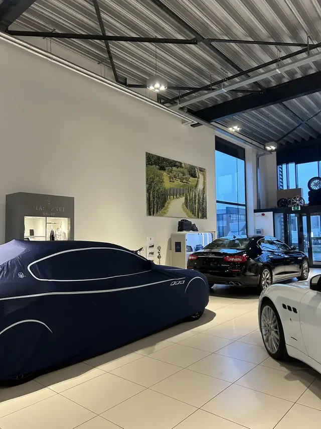 Maserati onder een autohoes in de showroom